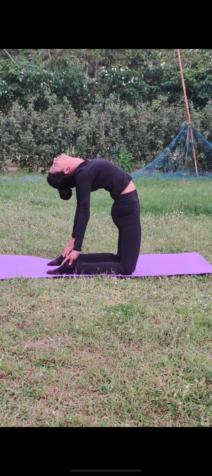 Priya in camel pose outdoors